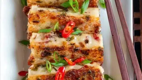 Sliced daikon bacon radish cake showcasing its moist texture and vibrant colors