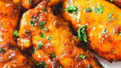 Honey Garlic Chicken Tenders garnished with herbs on a plate