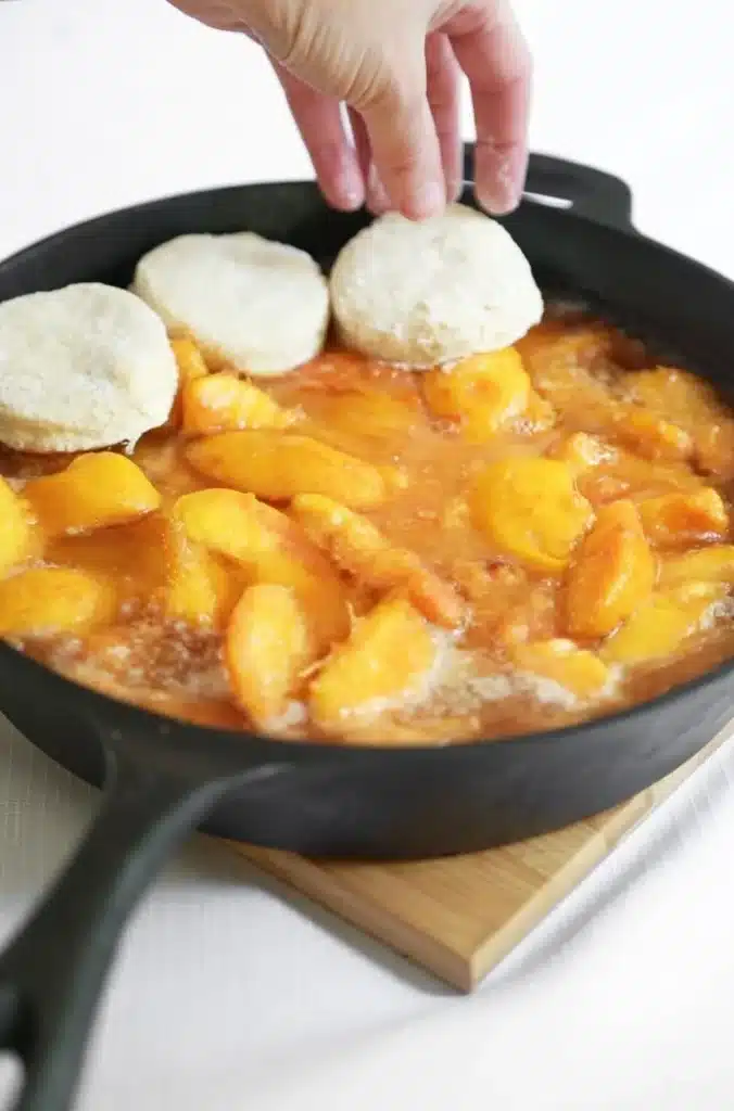 Skillet peach cobbler with a golden biscuit crust fresh out of the oven