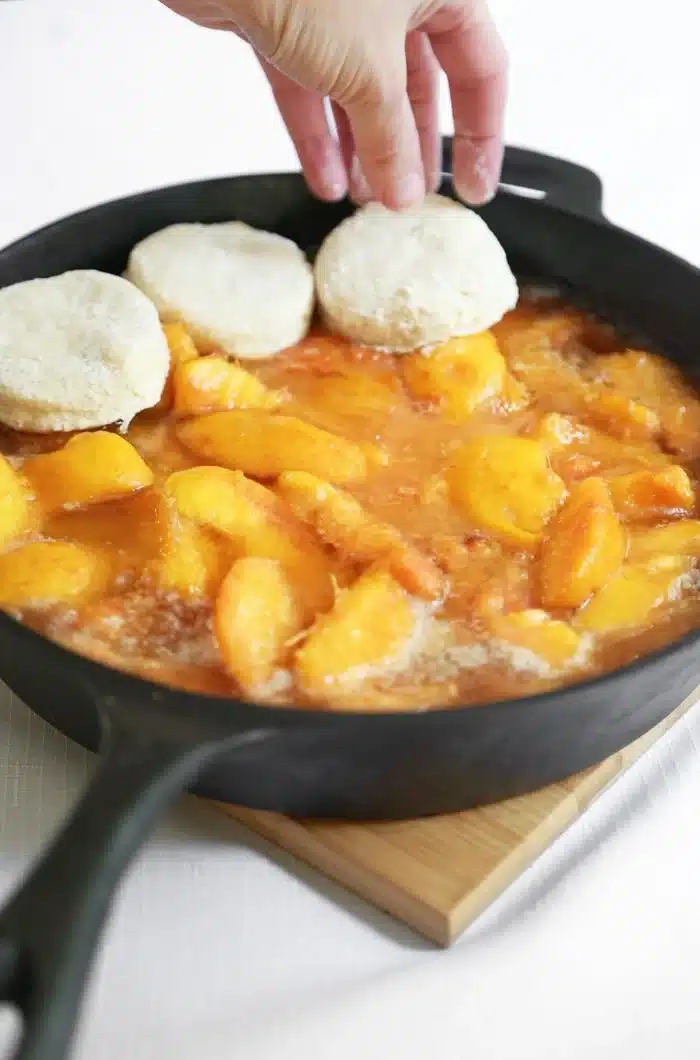 Skillet peach cobbler with a golden biscuit crust fresh out of the oven